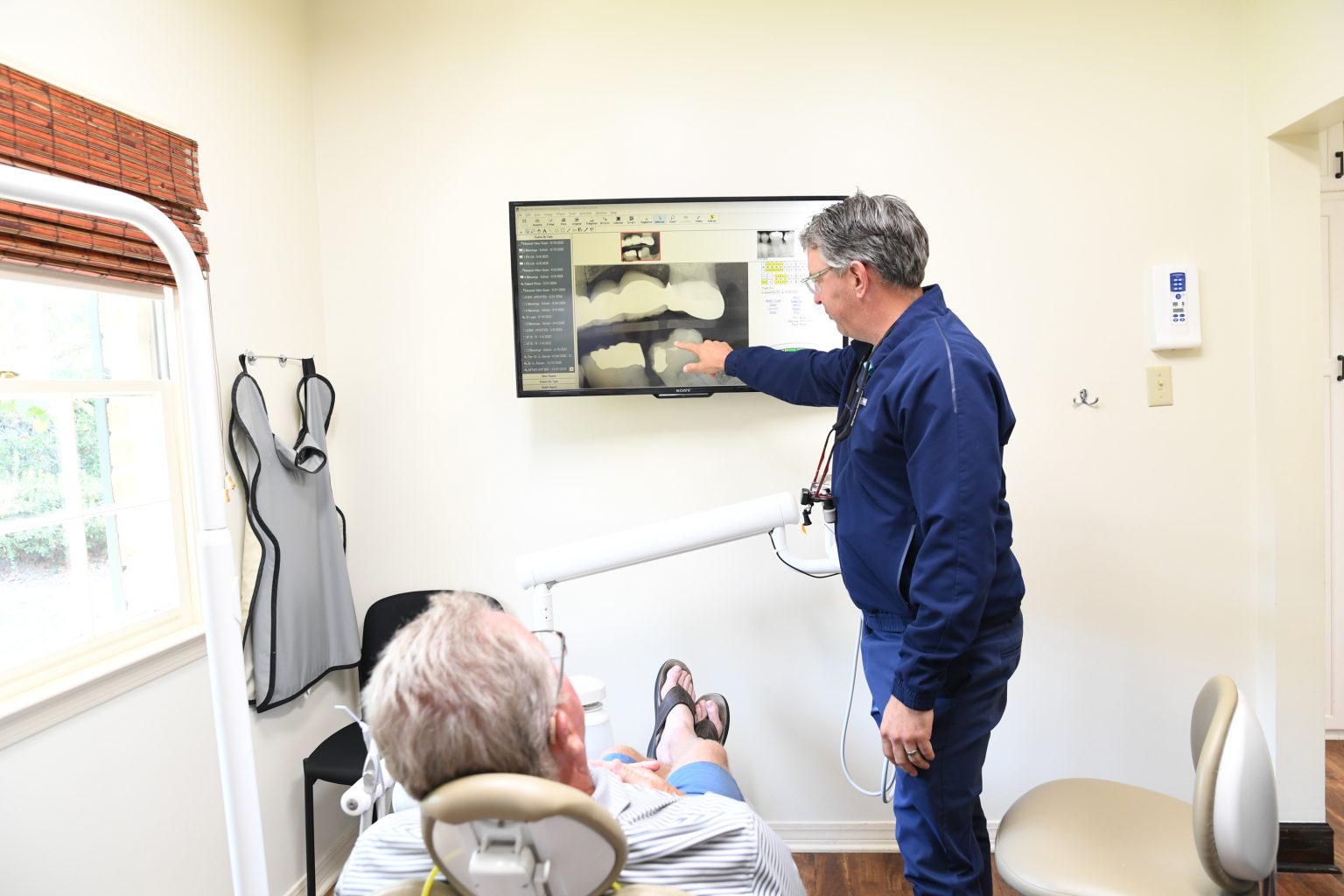 Dr. Crabtree reviewing dental X-rays with a patient at Maitre & Crabtree Dental Group in Mobile, AL